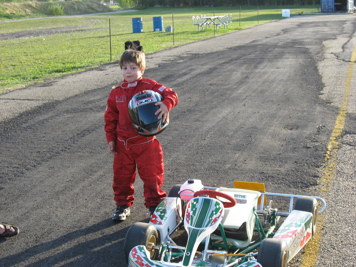 Griffin as a child beside a kart, holding a helmet